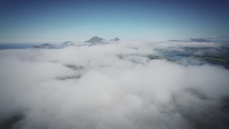 disparo de dron cinematográfico fpv estabilizado desde lofoten volando sobre las nubes con montañas a la vista