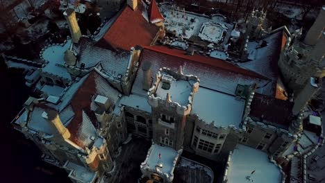 nieve fresca en el techo de tejas rojas de un antiguo castillo, el dron inclina la carretilla hacia afuera