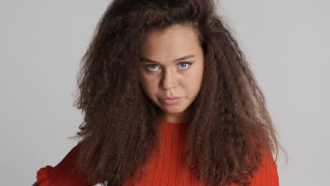 angry caucasian curly haired woman looking to the camera.