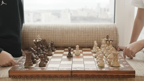 children playing chess by the window