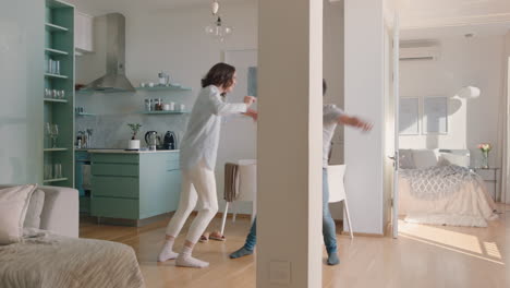 happy young couple dancing at home enjoying dance together having fun celebrating relationship