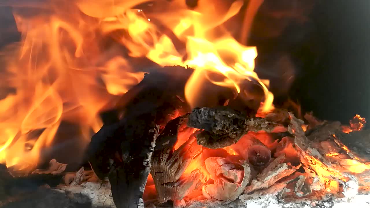 Flames of fire dancing above the pile of wood burning away, SLOMO