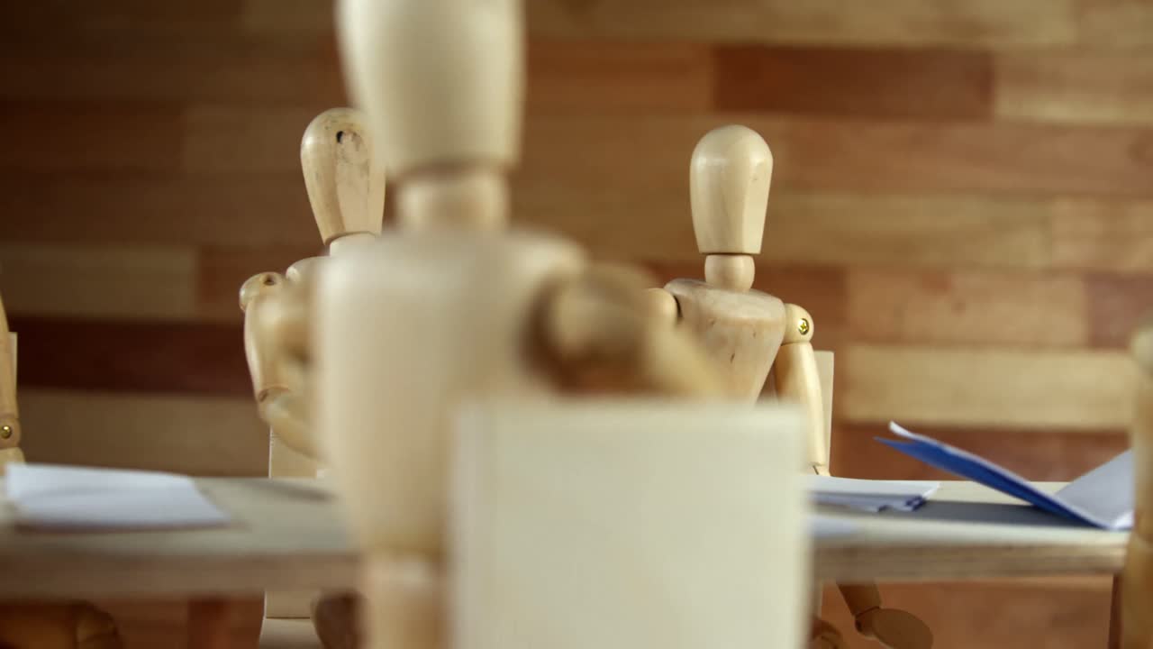 Statuette di legno che tengono una riunione in sala conferenze