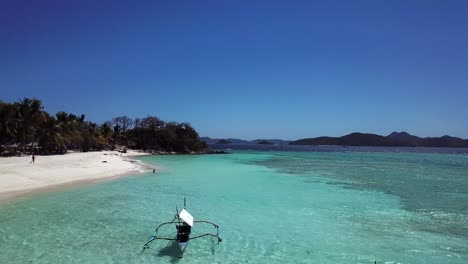 Beautiful-tropical-island-beach-with-clear-turquoise-water-and-boats