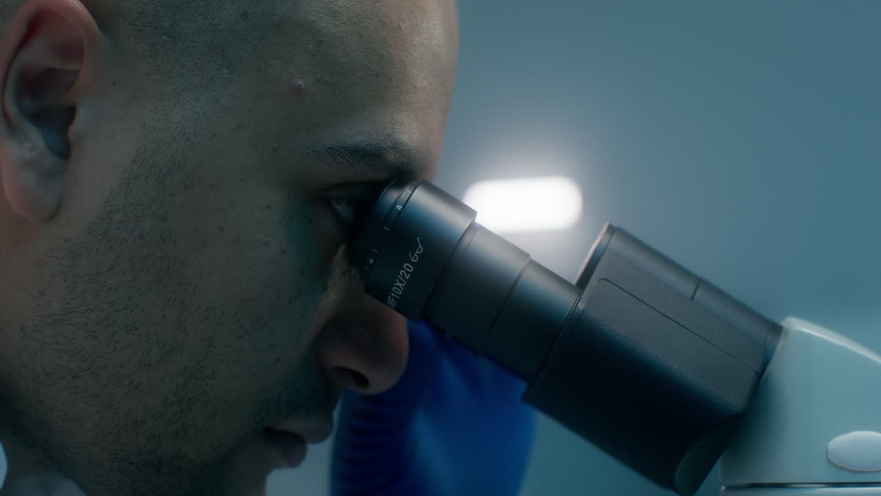 Científico mirando a través de un microscopio