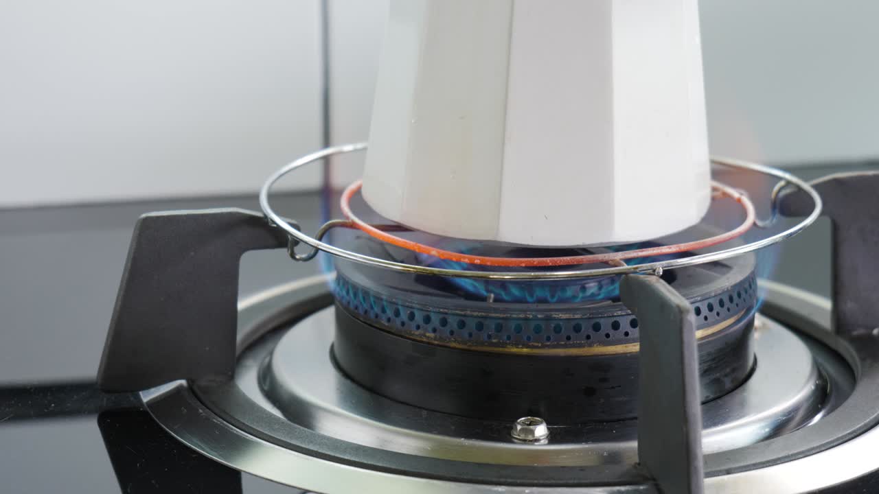 Brewing a drink by Italian Moka pot on portable gas stove.