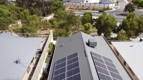Solar-panels-on-the-roof-of-building-with-vehicles,-trees-in-background