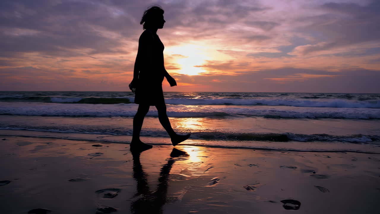 mujer caminando por la playa al atardecer