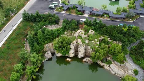 hermosa inclinación cinematográfica hacia abajo más vista de hélice de edificios tradicionales chinos turísticos con lagos y montañas de fondo en weihai, china