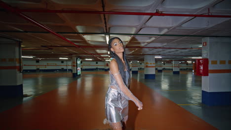 relaxed brunette crossing underground parking posing at night alone portrait