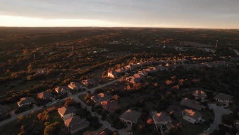 aerial shot over an american suburb and houses at sunset, dolly forward