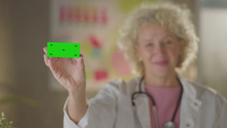 doctor holding a green screen business card