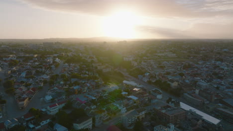 Fly-above-city-at-dusk.-Residential-buildings-and-streets-in-urban-borough-against-setting-sun.-Port-Elisabeth,-South-Africa
