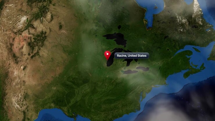 Satellite view camera zooms from space into Racine, Wisconsin, marked with a pin. Includes NASA public domain imagery.