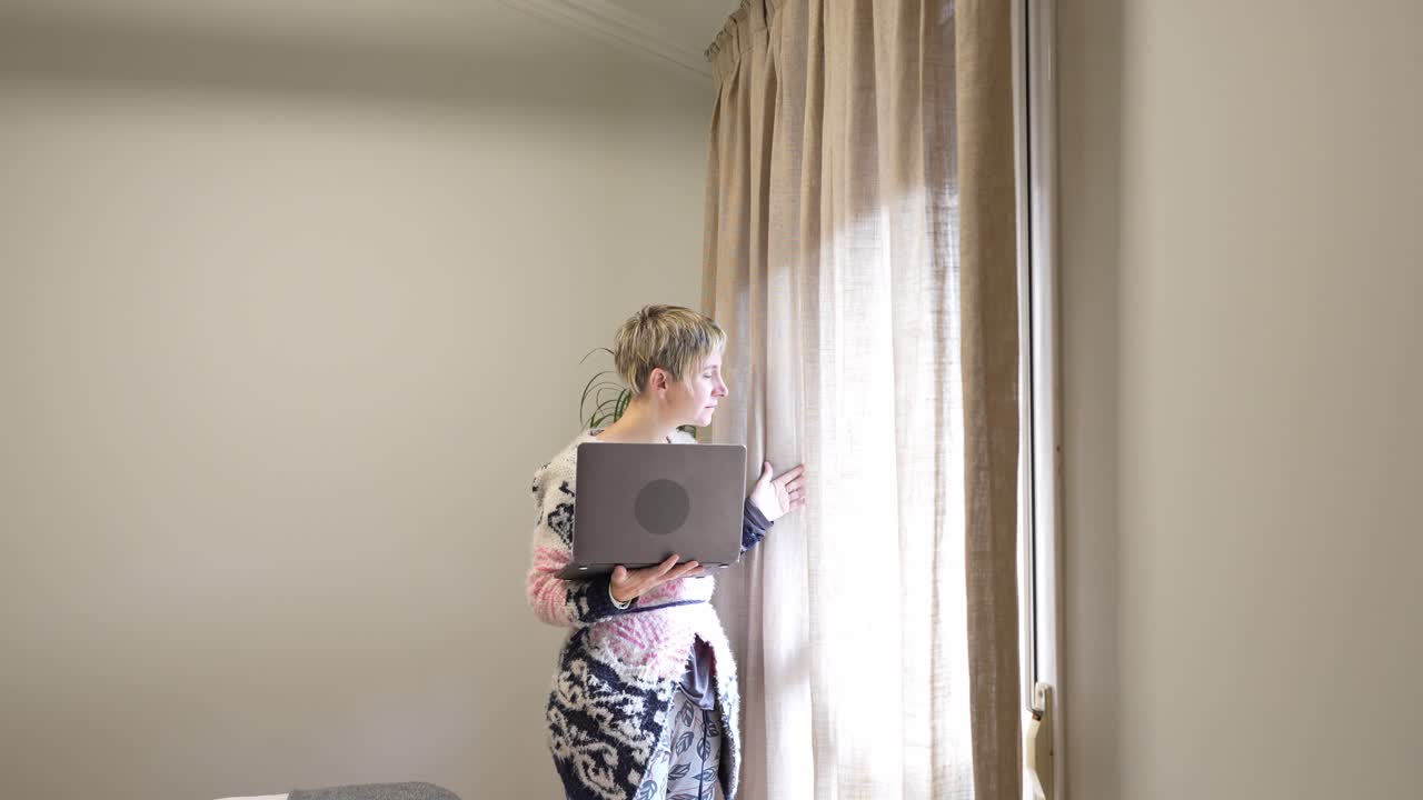 Mulher trabalhando no laptop perto da janela