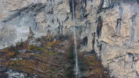 giant waterfall over the mountain rocks falling down on a bright day in lauterbrunnen, switzerland