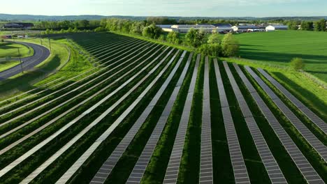 rural american landscape with modern solar panels farm on green grass field. sunny day in america during bright may day. aerial descending flyover shot. production on green clean energy outdoors.