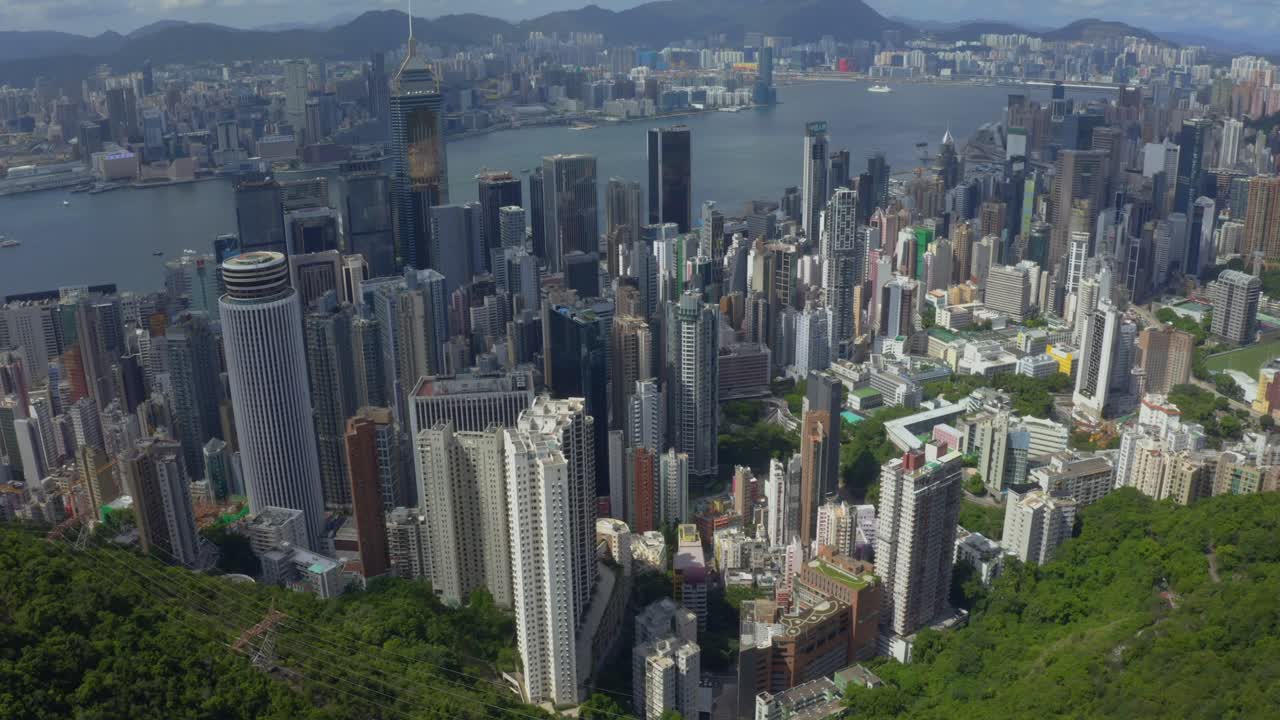 toma de viaje de drones hacia adelante de la ciudad de hong kong durante un día soleado con algunas nubes
