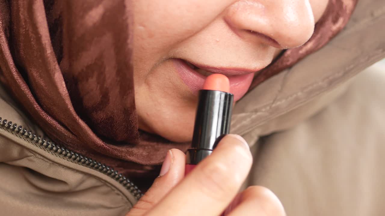 mujer aplicando lápiz labial