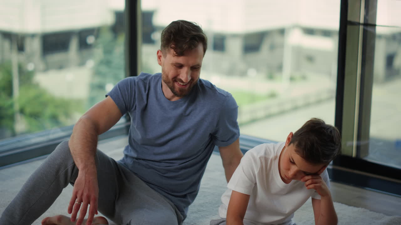 papá animando a su hijo durante el entrenamiento en casa. hombre y niño relajándose después del entrenamiento.