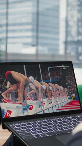 vertical video bucharest, romania - july 30th 2024 - businessman watching olympics live stream