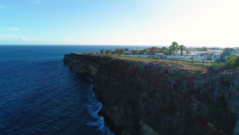 El-Dron-Se-Eleva-Sobre-Acantilados-Rocosos-Y-Grises-Hasta-Casas-De-Lujo-Con-Vistas-A-Las-Hermosas-Aguas-Del-Caribe,-Curazao.