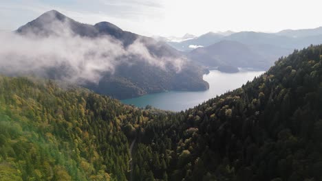 niebla en movimiento a través del horizonte sobre pintorescos montes alpinos y agua