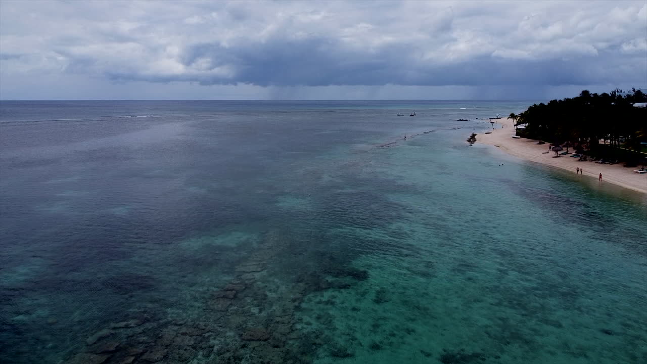 toma aérea hacia atrás de la isla paraíso con lluvia tormentosa en el fondo