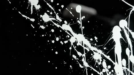 white paint splatter on black background