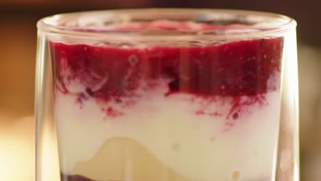 delicious layered dessert in a glass featuring creamy yogurt, velvety pudding, and rich berry compote for a tempting treat