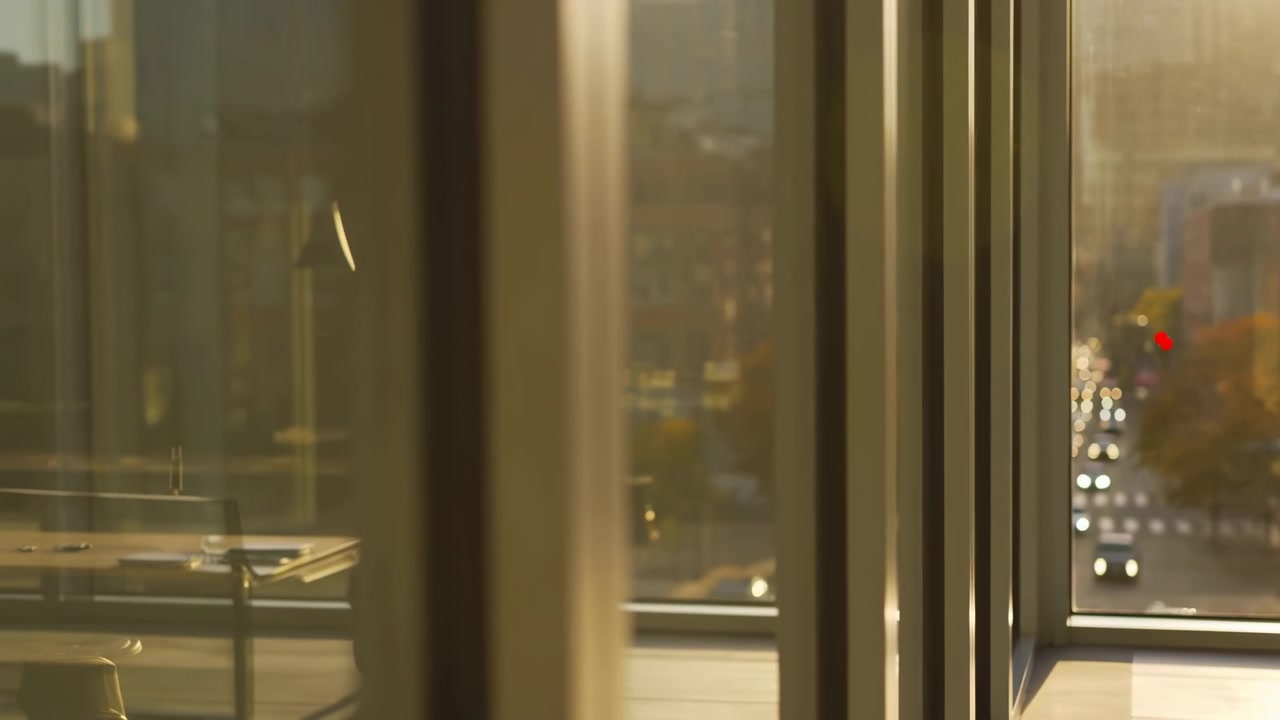 A glass elevator showing visible action, in interior of a modern building, with glass elevator, reflections in the glass, from a side view of the elevator perspective, with golden, brown accents.