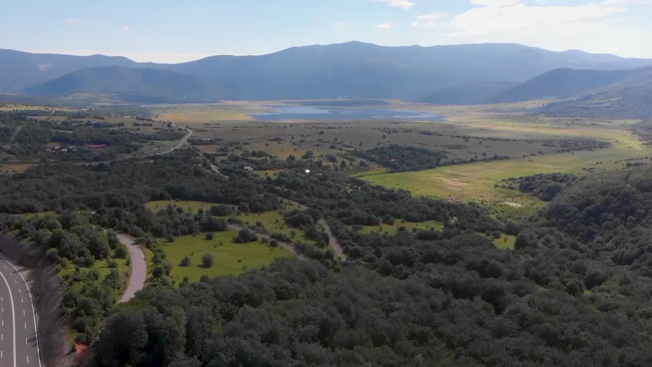 vista aérea ascendente de un valle verde con campos y agua