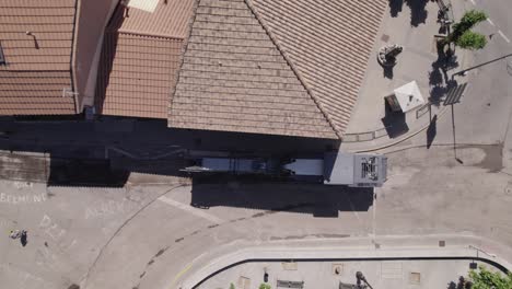 Aerial-view-looking-down-at-heavy-machinery-roadwork-asphalting-truck-ready-for-road-renovation-in-Navas-del-Ray,-Spain