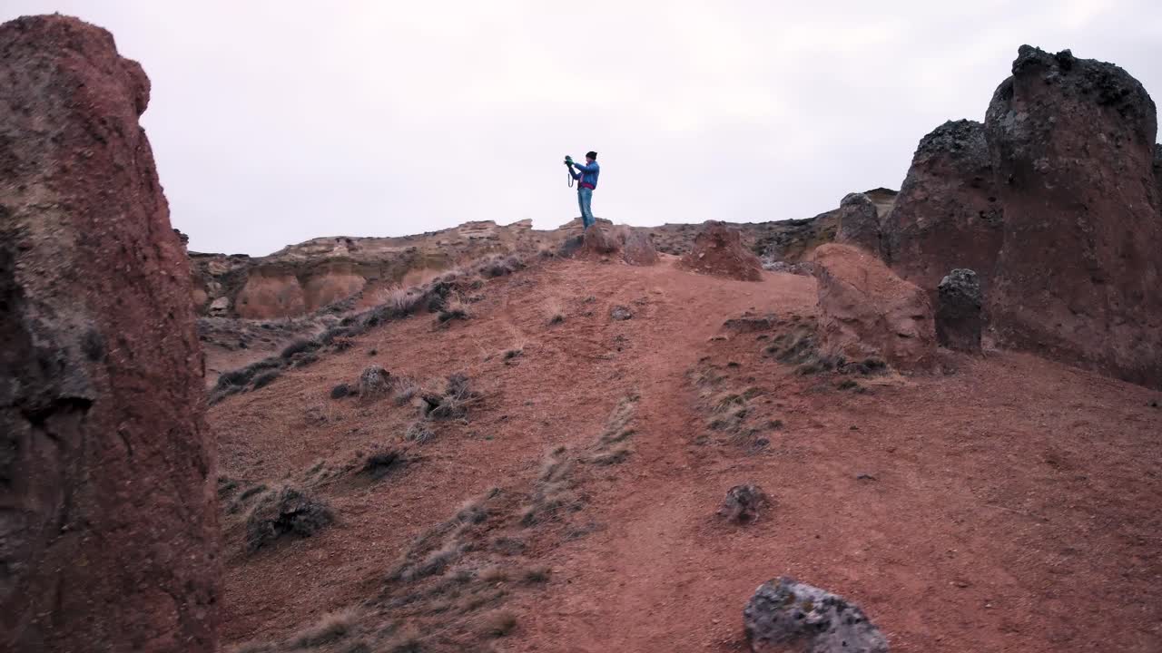 la antena de drones revela a una joven caucásica parada en un famoso destino turístico, valle imaginario de devrent, capadocia