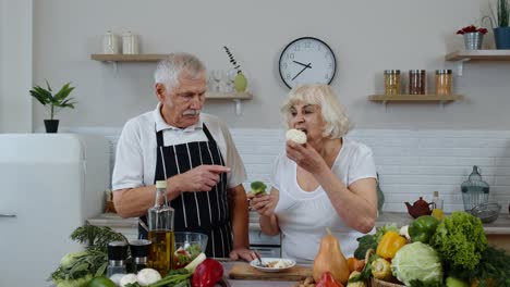 Pareja-Mayor-En-La-Cocina.-Abuela-Y-Abuelo-Ancianos-Comiendo-Brócoli-Y-Coliflor-Crudos