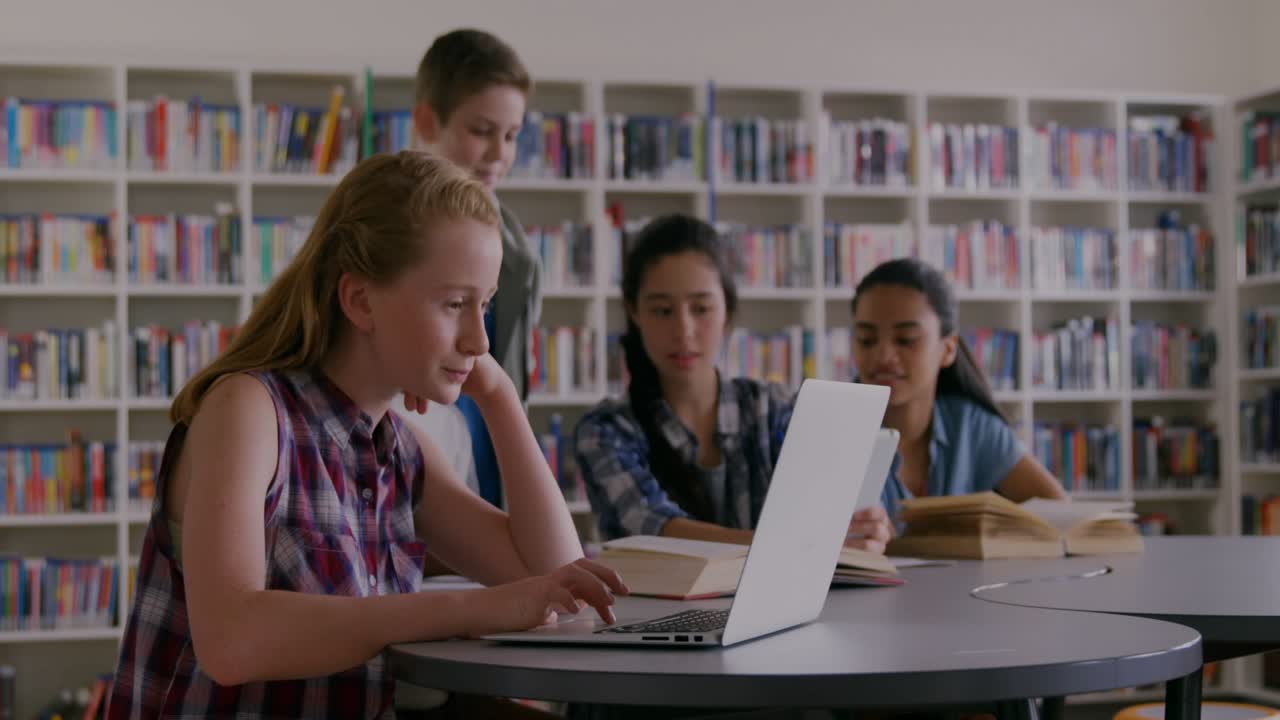 Four students typing at laptop in library, input initiating charts and streaming code for research