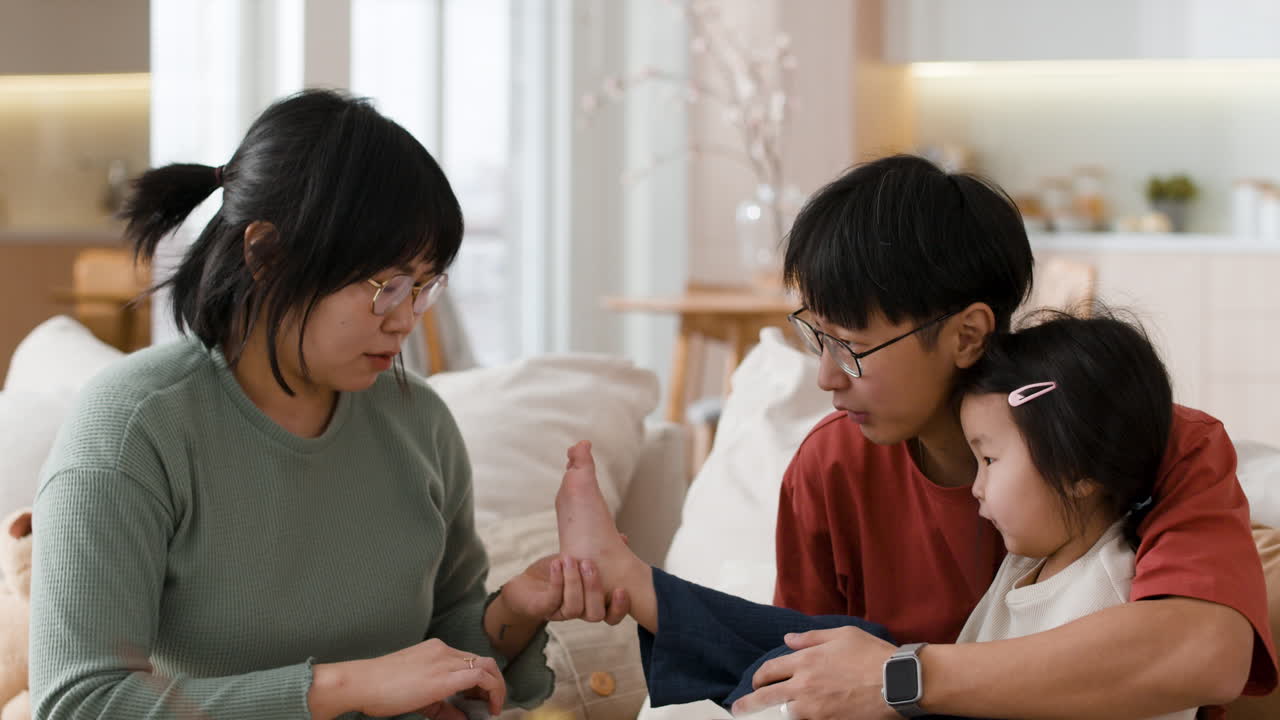 Family putting socks on daughter