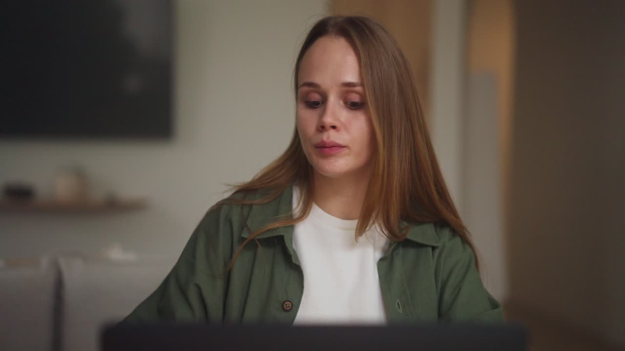 mujer trabajando en una computadora portátil y bebiendo café en casa