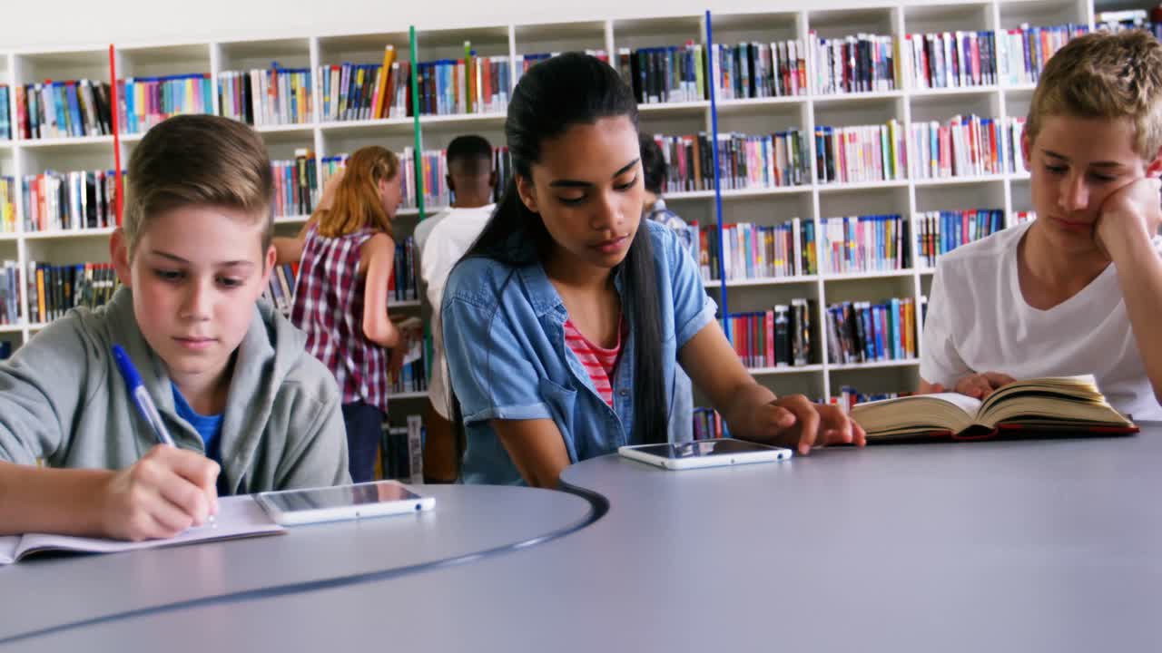 Scolari che studiano in biblioteca 4k
