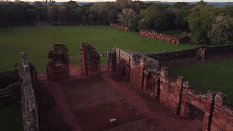 Dramatic-aerial-drone-footage-of-the-old-ruins-site-of-San-Ignacio,-Argentina-surrounded-by-a-luscious-green-forest