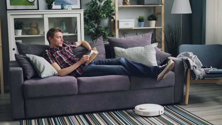 Hombre relajándose en el sofá y leyendo un libro en una sala de estar acogedora