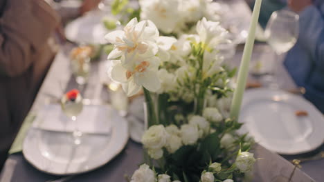 beautiful-romantic-flower-decoration-on-dinner-table-people-are-having-lunch-in-garden