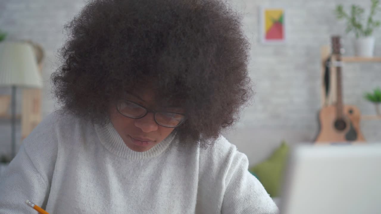 retrato de una hermosa mujer afroamericana con un peinado afro con lápiz en la mano
