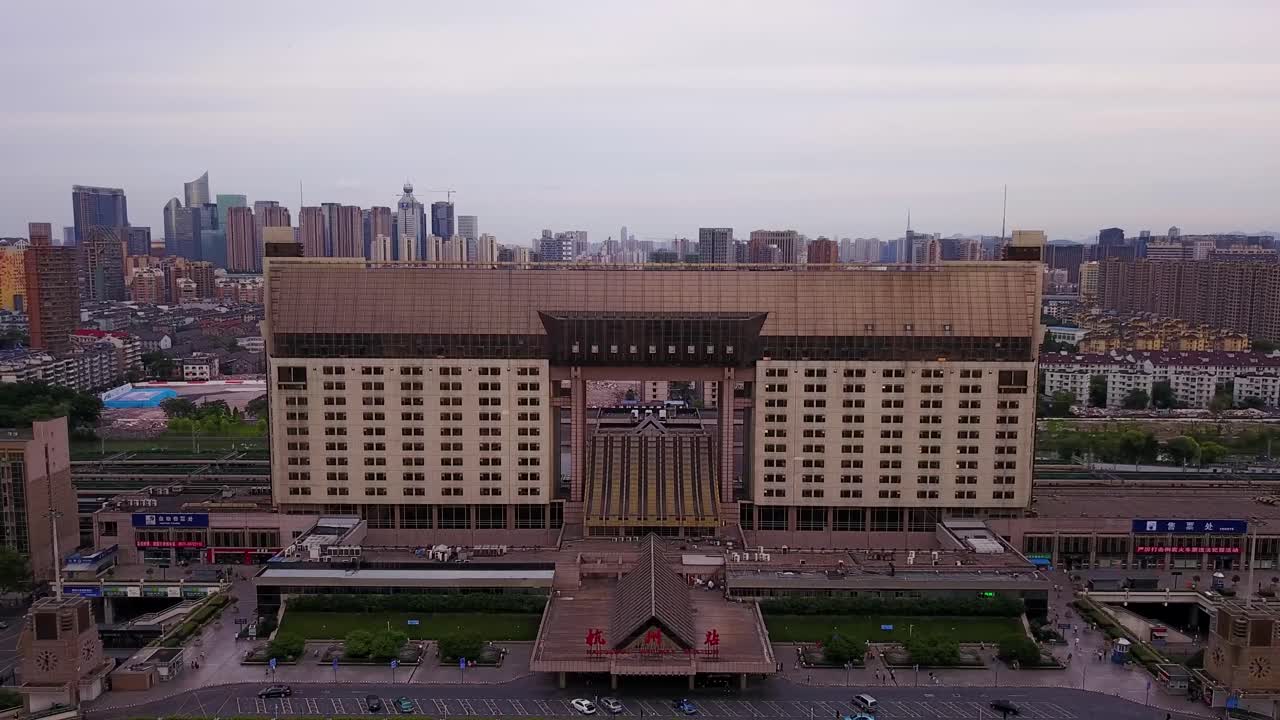 toma aérea del edificio de la estación de tren que se destaca con el horizonte de la ciudad en el fondo en un día nublado, hangzhou, china