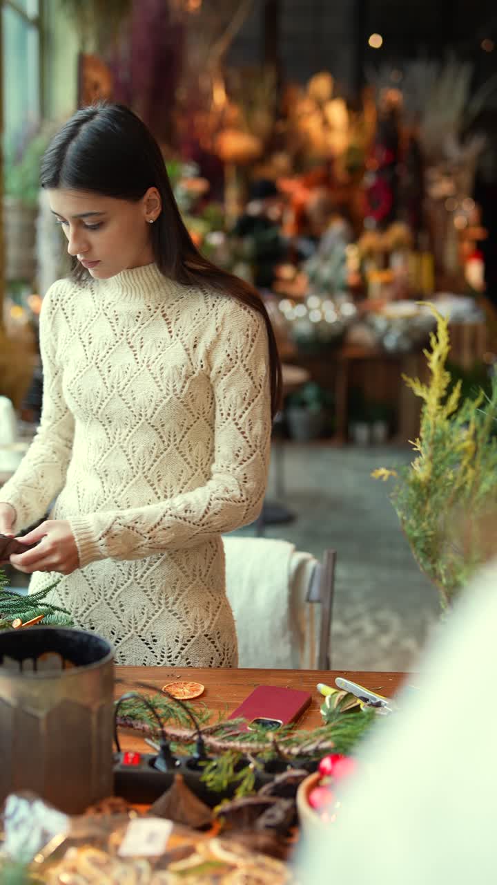 mujer haciendo decoraciones de navidad en una tienda de flores