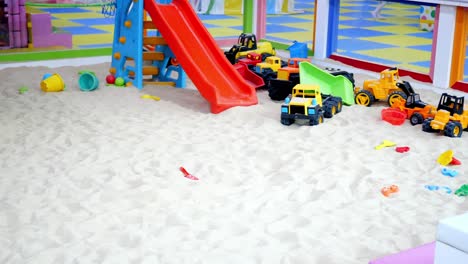 a colorful indoor sandbox with toys for kids