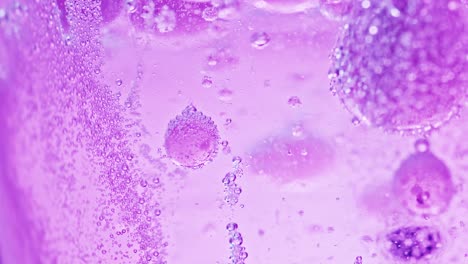 macro shot of many big and small violet bubbles in water moving around