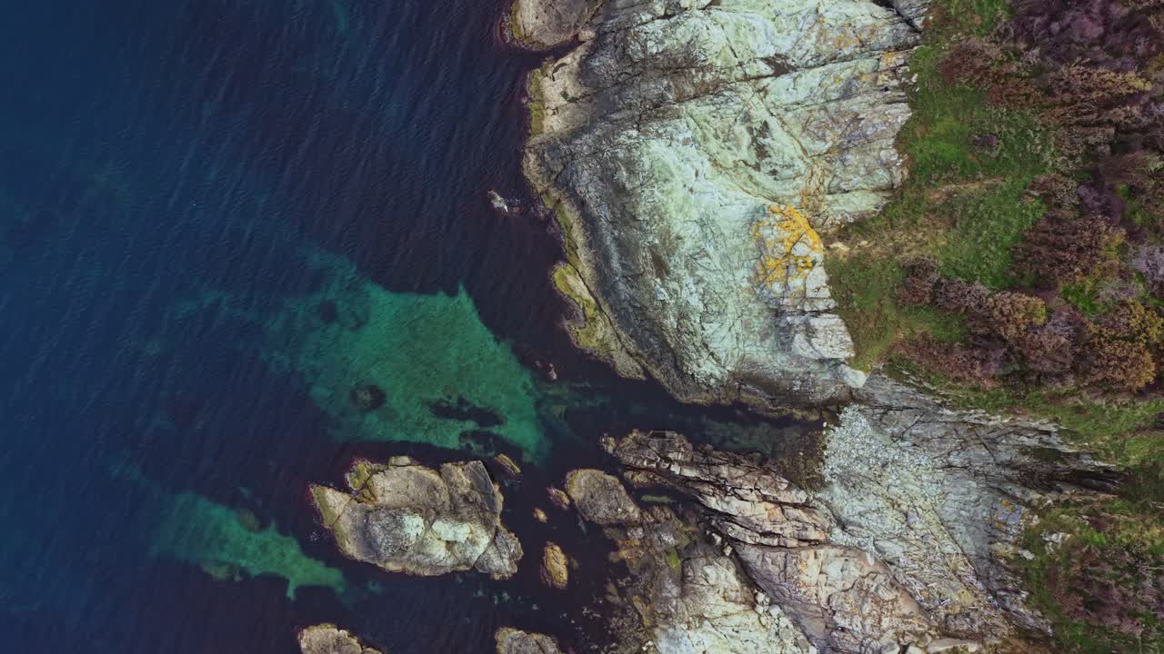 Scogliere costiere che incontrano acque cristalline in una splendida vista aerea del litorale