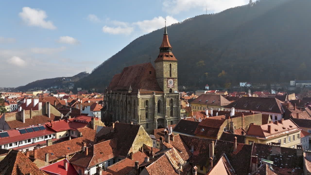 Aerial drone view of The Black Church in the city center of Brasov, Romania surrounded by mountains