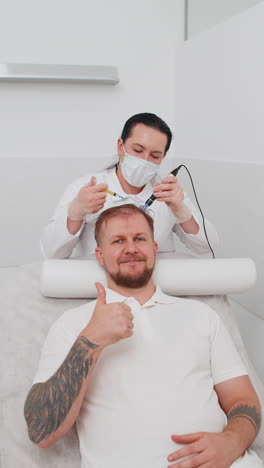 trichologist doing man improve hair growth procedure dermapen microneedling vitamin injections